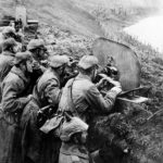In this 1916 photo, German troops man a machine gun post from a trench at the Vistula River in Russia during the First World War.