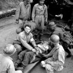 US and captured German medics attend to a wounded American soldier, 6 February 1944. During the Anzio campaign VI Corps suffered 29,200 combat casualties