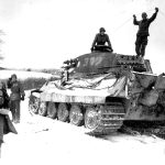 Two American soldiers inspect the abandoned then destroyed German King Tiger #312 tank while villagers look on smiling, Belgium, 1944