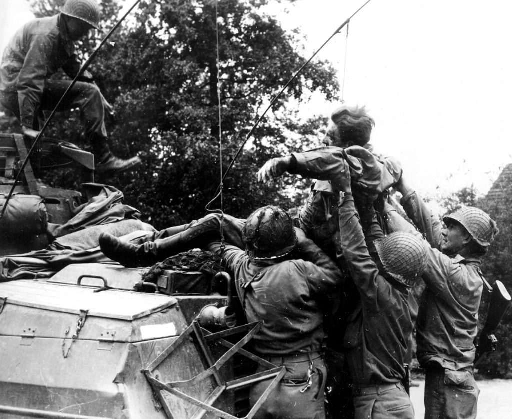 A wounded German prisoner is hoisted to an American armored car by a group of GI’s. He will be taken to a field hospital for treatment. Nazi was wounded during fighting in Belgium A wounded German prisoner is hoisted to an American armored car by a group of GI’s. He will be taken to a field hospital for treatment. Nazi was wounded during fighting in Belgium