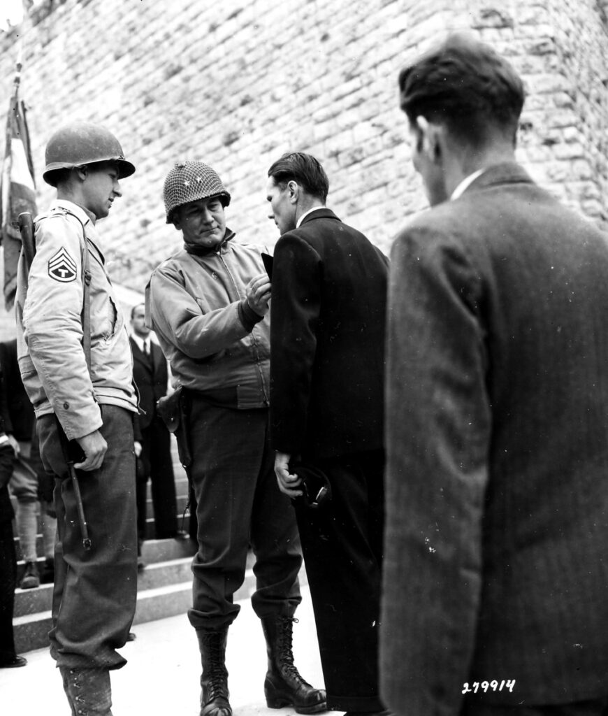 The CG of the 7-AD, Gen Sylvester, presents the Silver Star to Monsieur Frenand Legar of Verdun for saving a bridge vital to the American advance from destruction. September 5 1944