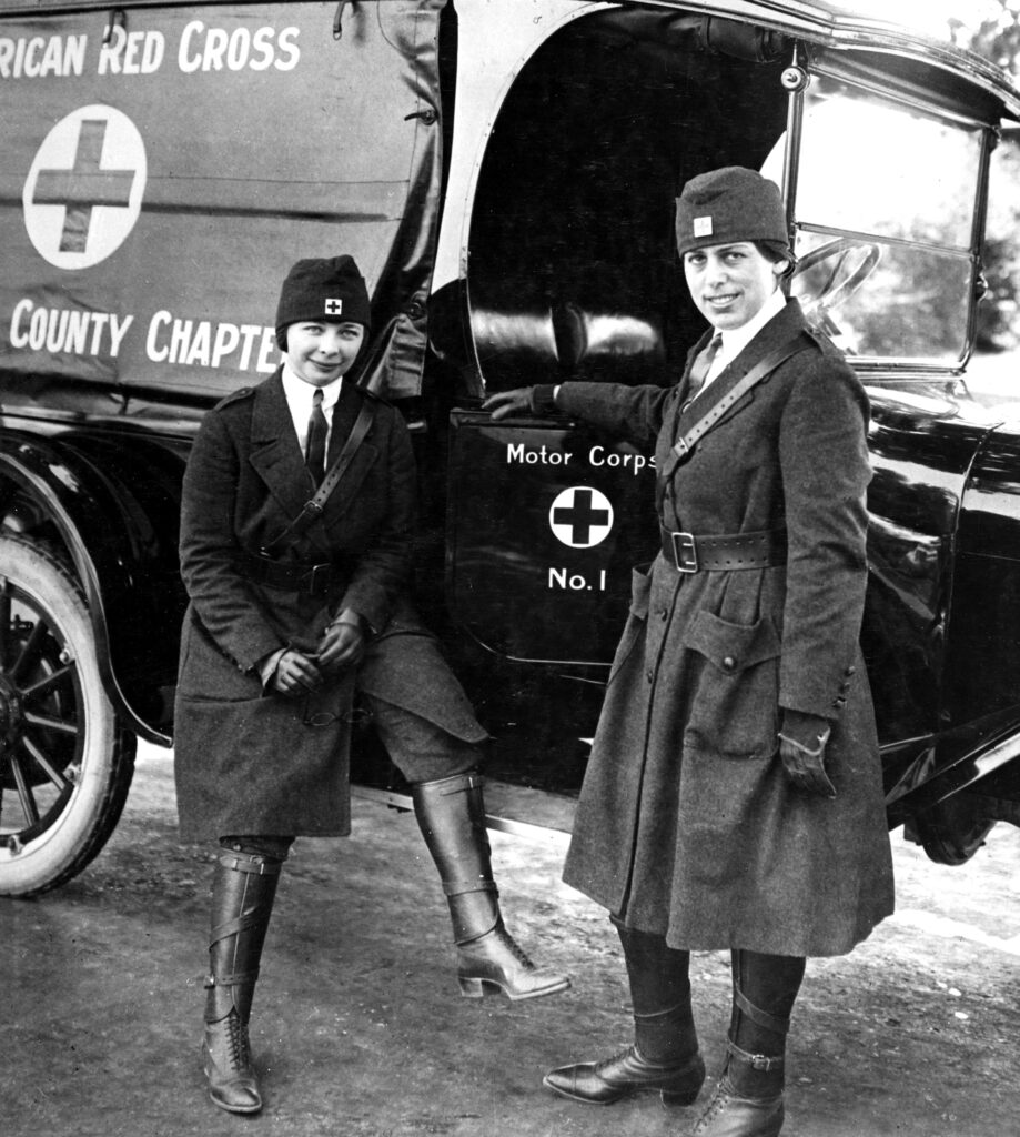(Illustration Red Cross) 1917 San Mateo, California. Two unidentified members of the San Mateo, CA County Red Cross Chapter proudly display their new uniforms and their shiny Motor Corps vehicle in a photo taken sometime during World War I