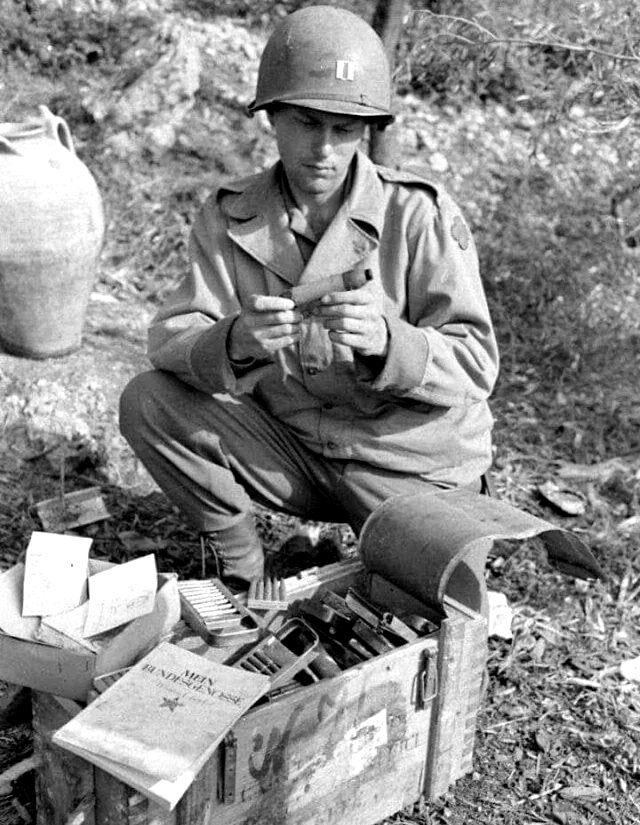 A Captain of the US 88th Infantry Division examining captured Axis munitions during the advance through Italy A Captain of the US 88th Infantry Division examining captured Axis munitions during the advance through Italy