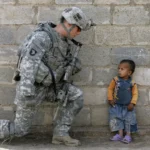 A US soldier with an Iraqi child in Baghdad, 2008 – Mauricio Lima – AFP – Getty Images