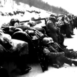Marines of the 5th and 7th regiments who hurled back a surprise onslaught by three Chinese communist divisions wait to withdraw from the Chosin Reservoir area circa December 1950