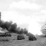 An ammunition carrier of the 11th Armored Division explodes after it is hit by a German mortar round – Normandy 1944
