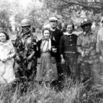 Pfc. Guth and Sgt. Talbert from E Company, 506th Parachute Infantry Regiment, pose with French citizens on the morning of the D-Day landings.