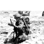 A soldier from 1st Battalion, 382nd Infantry Regiment fixing a bayonet on his rifle after arriving on Leyte, October 20, 1944