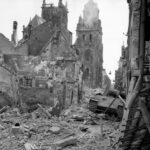 German Panther tank lies among the ruins of Argentan, France – August 21, 1944.