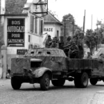 Retreating German soldiers riding on armored truck, Dreux, June 1944