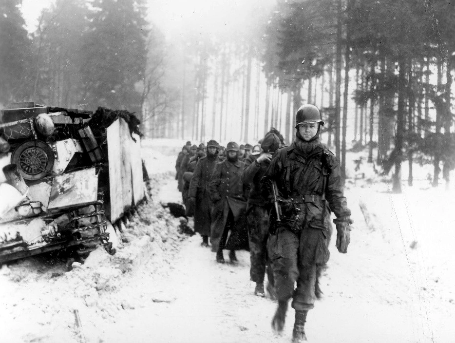 An 82nd A/B Trooper escorts German Pows to the Pows Cage January 1945
