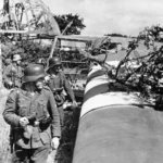 An abandoned Waco CG-4 glider is examined by German troops