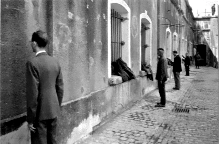 Newly arrived prisoners or punished ones standing at the wall