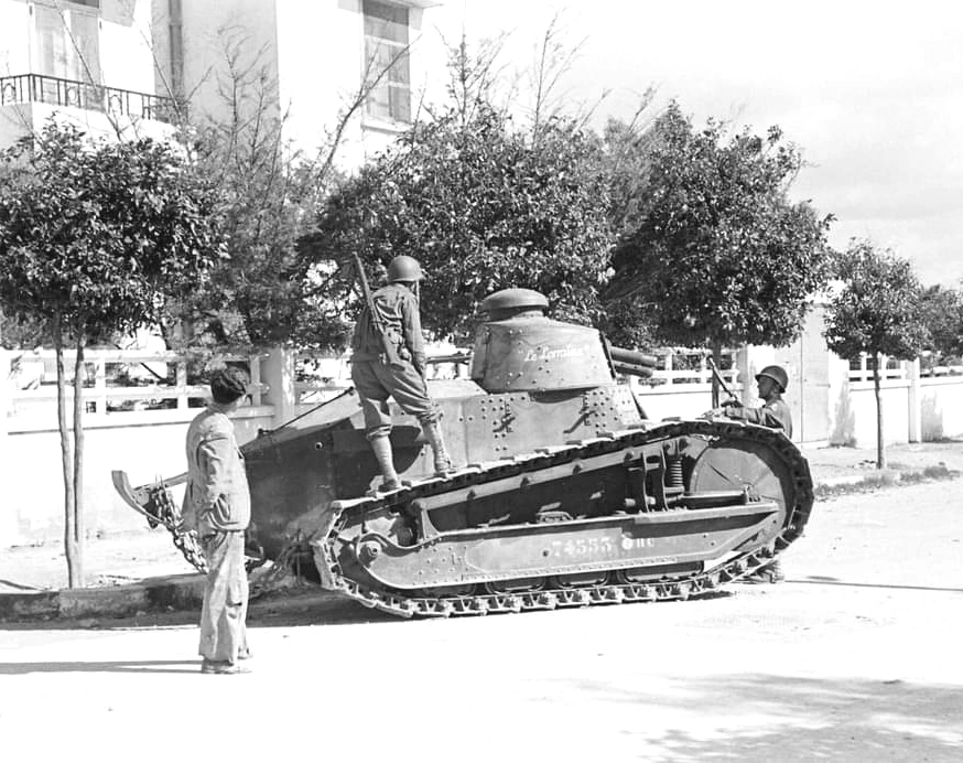 Abandoned-or-damaged Vichy French Renault FT-17 tanks are examined by curious US Personnel