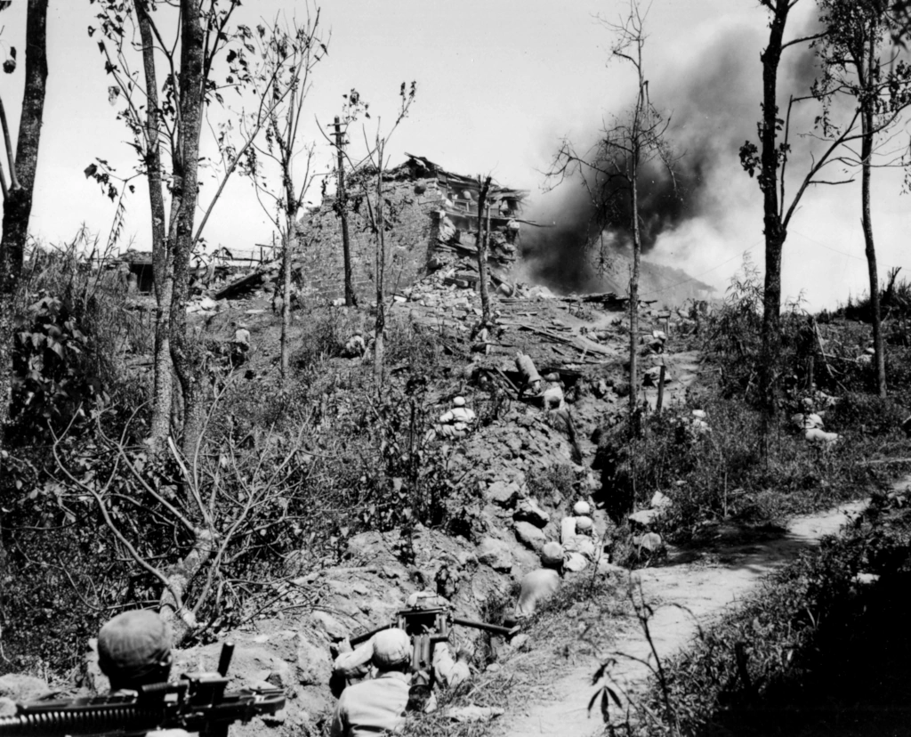 Chinese soldiers in a trench watch the destruction of Japanese fortifications during the assault on Tengchong