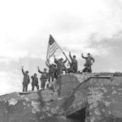 1944, American troops raise the Stars and Stripes over a German gun bunker after winning the battle for St, Malo, France(scaled)