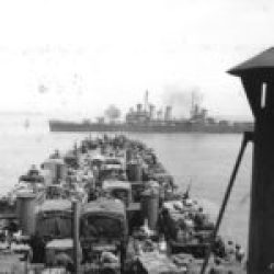 2-AD-EUCMH-Operation Husky-Sicily-1943-USS Boise engaging enemy armor as LST-325, with its load of US Army vehicles, approaches the landing beaches near Gela, Sicily, 11 Jul 1943