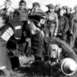 A Wehrmacht veteran teaches Hitler Youth boys how to use a Panzerfaust. The badges on his sleeve represent enemy tanks destroyed