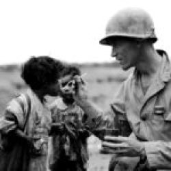 American Army Lt. Richard K. Jones sharing his food rations with pair of young Japanese children found hiding in an abandoned tomb