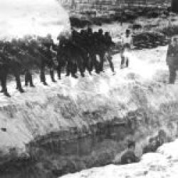 Einsatzgruppen soldiers shooting Jews who are in a ditch
