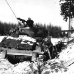 M4A3E8 tank of the US 4th Armored Division covers one of the roads towards Bastogne