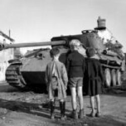 Three French boys looking at a knocked-out German Panther tank in the Falaise pocket, Normandy, 25 August 1944